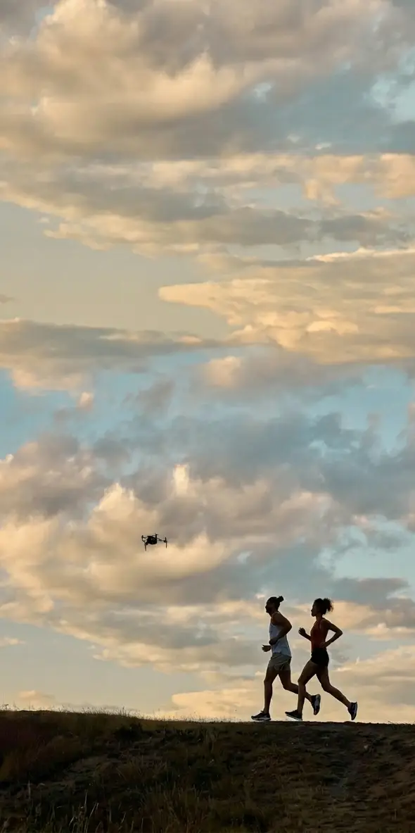 Dron Levi sobrevolando a dos corredores en la montaña